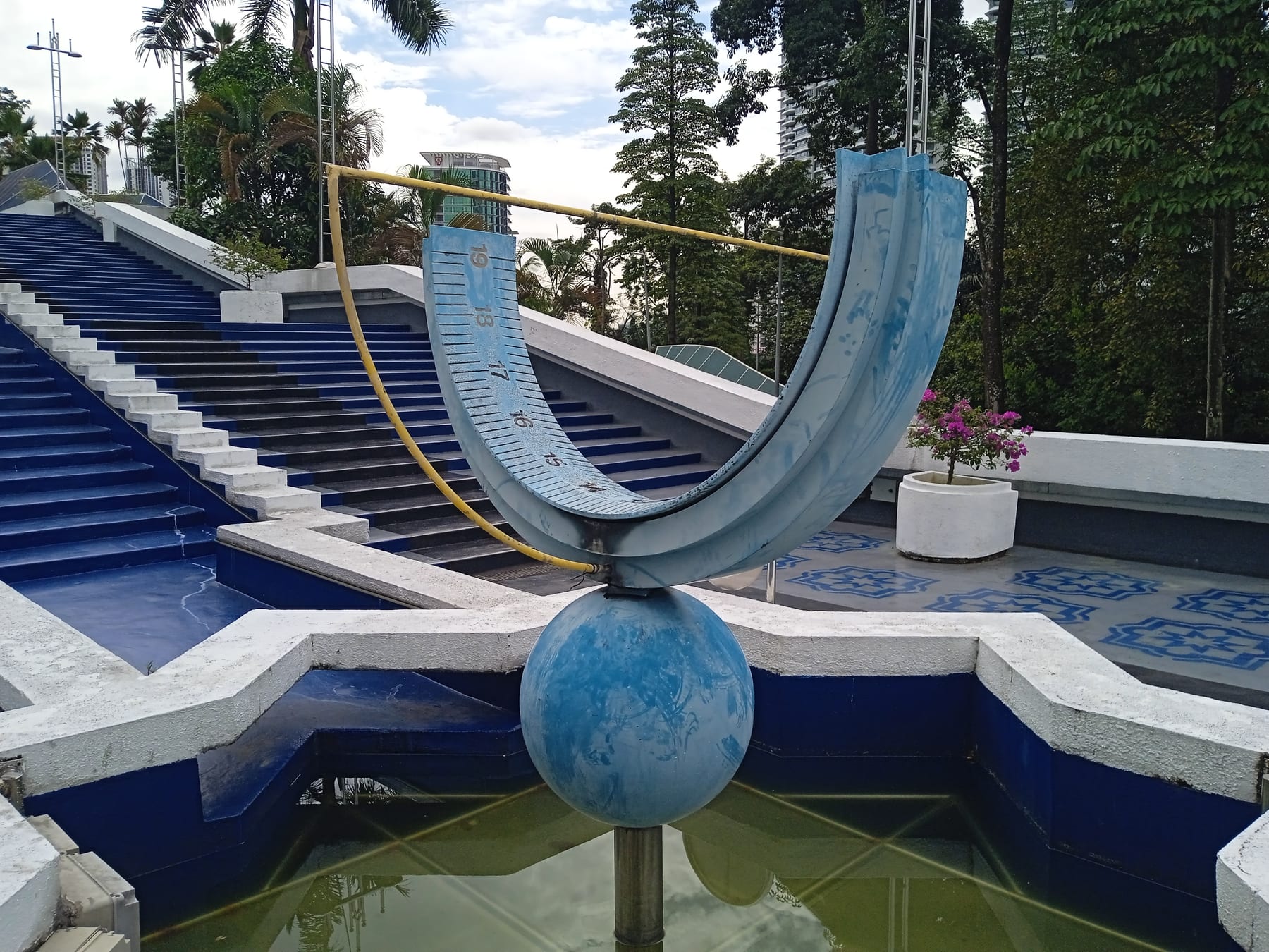 A modern semi-equatorial sundial on a stepped concrete base at the National Planetarium, Kuala Lumpur.